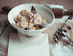 Ready dumplings in a plate on a wooden board