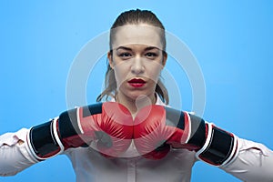 Ready for a fight. Determined business woman wearing boxing gloves.