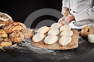 Ready formed loaves of bread on a wooden paddle