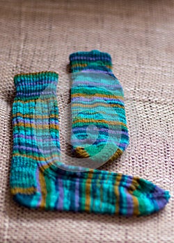 Ready-made knitted sock from green striped yarn, handicrafts as a hobby, knitting concept