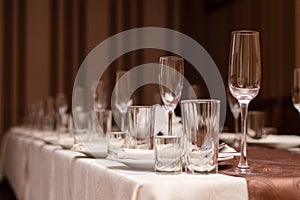 Ready for party: Restaurant table layout with row og wineglasses