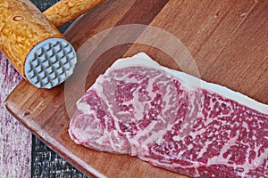 Ready raw fresh steak as wagyu beef  MS5+ with meat hammer on butcher served  for cooking