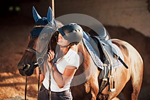 Ready for the ride. Horsewoman in uniform and black protective helmet with her horse