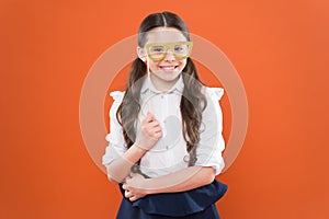 She is ready. school girl in uniform. child with party glasses. smart and intelligent kid on orange background. back to