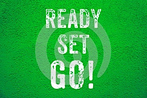 Ready Set Go! white words text on green grungy stucco cement wall background motivational message banner
