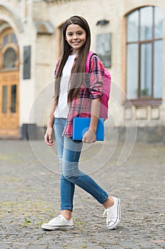 Ready for studies. Happy child carry bag and book in schoolyard. Back to school. September 1. Startup. Non-formal