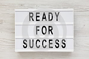 `Ready for success` words on a modern board on a white wooden background. Overhead, from above, flat lay