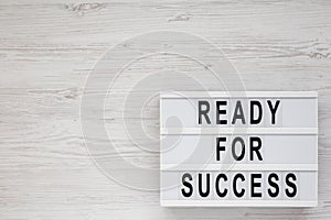 `Ready for success` words on a modern board on a white wooden background, top view. Overhead, from above, flat lay. Space for te
