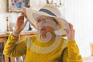 ready for summer - senior woman in hat at home medium closeup living room seniority concept