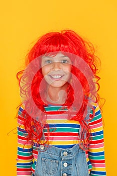 Ready for super party. Party girl yellow background. Happy child wear red colored party wig. Perfect look for cosplay or