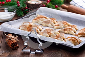 Ready to bake Christmas tree shaped puff pastry cookies with sugar and cinnamon, cookie cutter