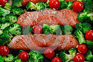 Ready to bake raw salmon fillet with broccoli and tomato, horizontal, top view, closeup