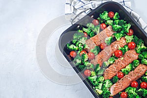 Ready to bake raw salmon fillet with broccoli and tomato, horizontal, top view, copy space