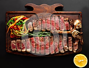 Ready to be served porterhouse steak with vegetables on wooden serving board