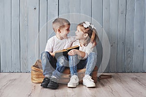 Ready to big travel. Happy little girl and boy reading interesting book carrying a big briefcase. Freedom and