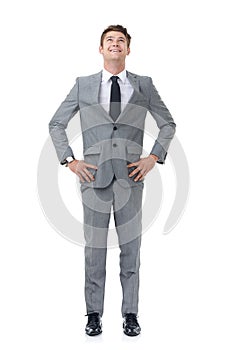 Ready to climb the corporate ladder. A young businessman standing with his hands on his hips looking upwards.