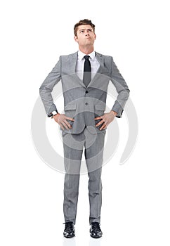 Ready to climb the corporate ladder. A young businessman standing with his hands on his hips looking upwards.