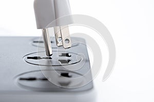 Plugging electrical, black plug in electric socket, close up shot