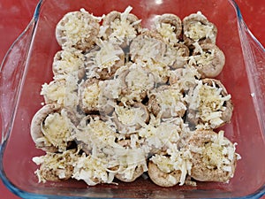 Ready to cook mushrooms with cheddar cheese in the glass tray