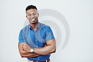 Always ready to create. Studio portrait of a young creative businessman posing with his arms crossed against a grey