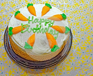 ready to eat Happy Birthday carrot cake with white frosting and carrots