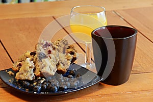 Buttered berry muffin with coffee and orange juice