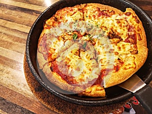 Ready to eat a pizza on pan with wooden background