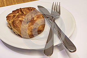 Ready to eat turkish rose pastry borekwith white cheese in white plate with spoon and fork