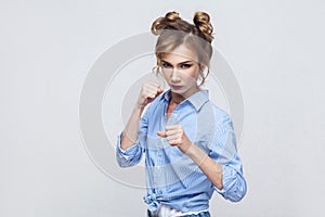 Ready to fight! Aggressive women with bun hair looking at camer