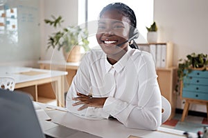 Ready to lead the charge. a young businesswoman using a headset and laptop in a modern office.