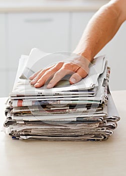 Ready to make something else. Cropped shot of a man with a stack of newspaper.