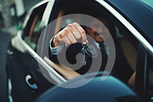 Ready to ride in luxury. a businessman holding the keys to a luxury car.