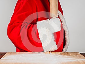 Ready to start cooking. Santa Claus in traditional costume holds a rolling pin. Cooking, holiday food concepts