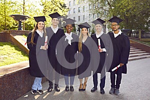 Ready to success. Six college graduates standing in a row and smiling.
