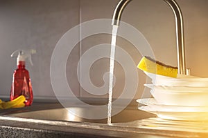 Ready to wash the dirty dishes with sponge in kitchen sink, selective focus with place for your text