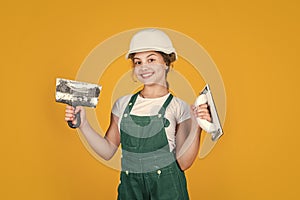 Ready to work. happy girl use spatula tool. teen builder wear safety helmet. young worker in protective hard hat