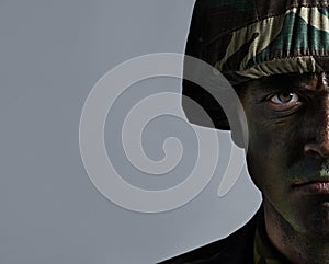 Ready for war. Headshot of a serious military man with his face camouflaged.