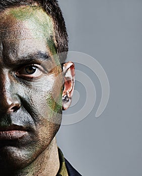 Ready for war. A young military man wearing camouflage facepaint.