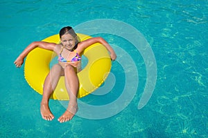 Real adorable girl relaxing in swimming pool