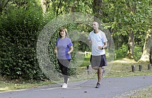 Real Adult Latino Couple Playing Sports and Running in a Green Park to Lose Weight Before Summer