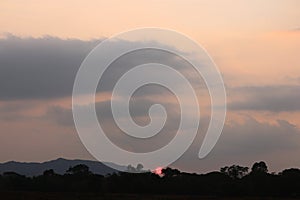 Real amazing panoramic sunrise or sunset sky with gentle colorful clouds. Sunset Sunrise Sundown Sky