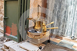 Real Arabic coffee brewing over charcoal with an authentic copper kettle and fenjans in Nazareth old city in northern Israel