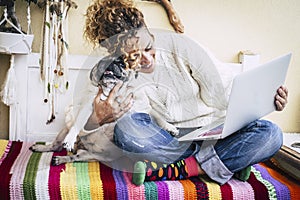 Real best friends cheerful woman working at laptop on the terrace at home while hug her best love and friends smiling dog pug