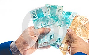 Real - Brazilian Currency. Man holding several money bills. photo