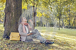 Real businesswoman with tablet laptop at work outdoors in park