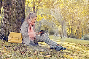 Real businesswoman with tablet laptop at work outdoors in park