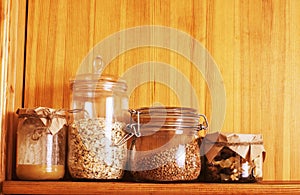 Real comfort wooden kitchen with breakfast ingredients close up in glass, honey, oatmeal, milk, muesli