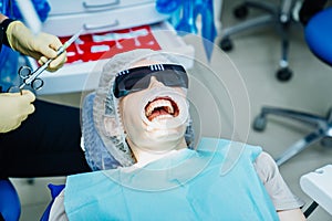 real. dentist injects an anesthetic into patient before tooth extraction