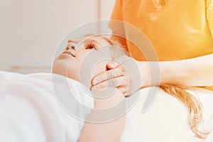 Real doctor osteopath hands does physiological and emotional therapy for eight year old kid girl. pediatric osteopathy treatment s