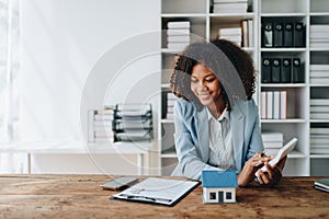 Real estate agent, African American businesswoman Africans use smartphone and calculators to offer mortgages to their